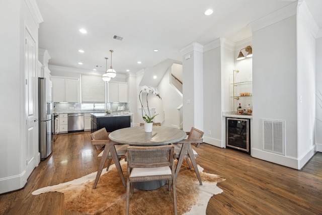 1010 W 24th St Unit N, Houston, TX 77008 - dining area with beverage cooler, a dry bar, dark wood finished floors, ornamental molding, and recessed lighting