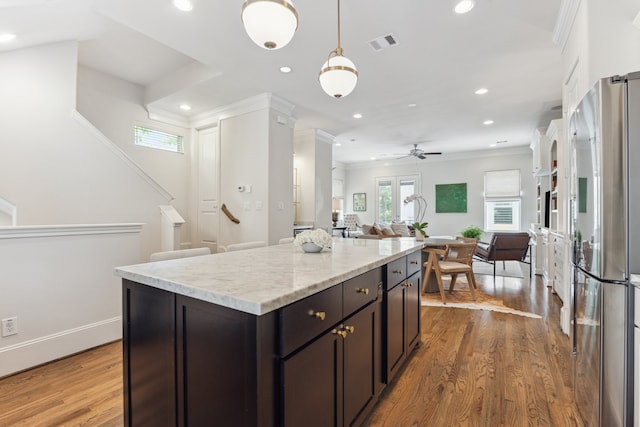 1010 W 24th St Unit N, Houston, TX 77008 - kitchen featuring stainless steel fridge, healthy amount of natural light, ornamental molding, wood finished floors, and recessed lighting
