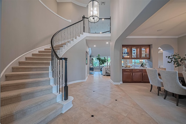 18315 Cape Lookout Way, Humble, TX 77346 - entrance foyer featuring arched walkways, light tile patterned floors, stairway, a chandelier, and ornamental molding