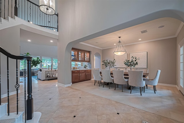 18315 Cape Lookout Way, Humble, TX 77346 - dining room with arched walkways, light tile patterned floors, ornamental molding, recessed lighting, and stairs