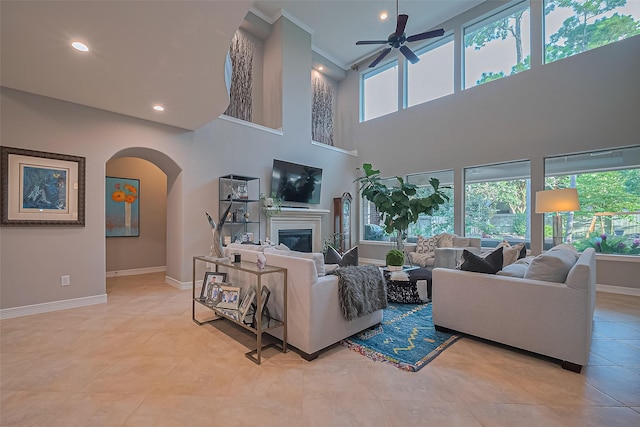 18315 Cape Lookout Way, Humble, TX 77346 - living room with plenty of natural light, arched walkways, ceiling fan, a glass covered fireplace, and a towering ceiling