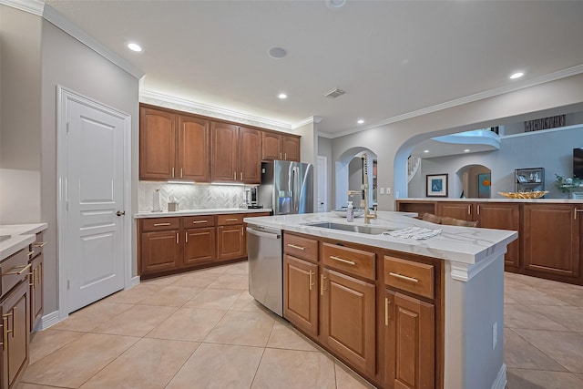 18315 Cape Lookout Way, Humble, TX 77346 - kitchen with appliances with stainless steel finishes, crown molding, light tile patterned floors, decorative backsplash, and arched walkways