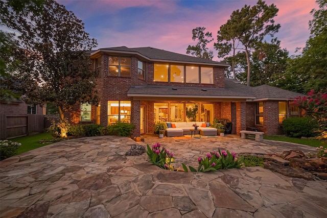 18315 Cape Lookout Way, Humble, TX 77346 - back of property at dusk featuring an outdoor living space, a patio, and brick siding