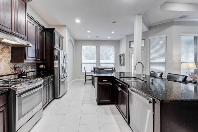 2302 Lakecrest Gardens Dr, Katy, TX 77493 - kitchen with appliances with stainless steel finishes, decorative backsplash, dark stone counters, light tile patterned floors, and recessed lighting