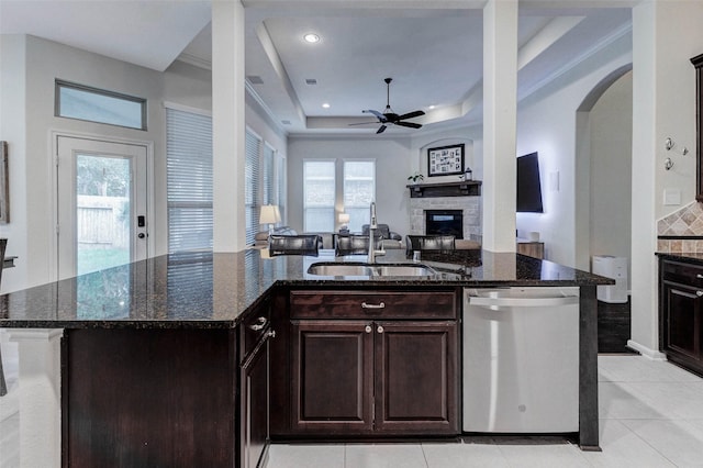 2302 Lakecrest Gardens Dr, Katy, TX 77493 - kitchen with stainless steel dishwasher, a fireplace, ceiling fan, dark stone counters, and recessed lighting