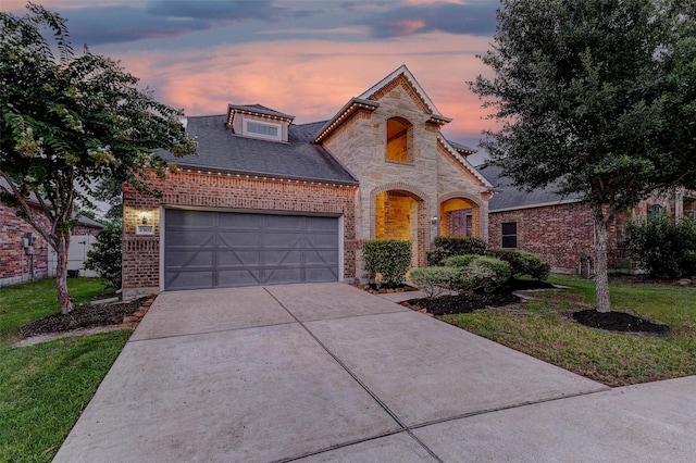2302 Lakecrest Gardens Dr, Katy, TX 77493 - french provincial home featuring driveway, stone siding, an attached garage, brick siding, and a front yard