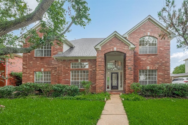 1615 Monvale Ln, Sugar Land, TX 77479 - traditional home featuring brick siding, a front yard, and a shingled roof