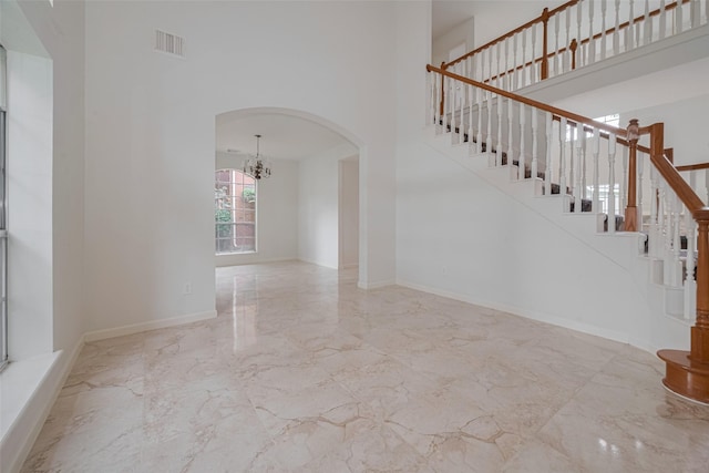 1615 Monvale Ln, Sugar Land, TX 77479 - staircase with marble tiled flooring, a high ceiling, arched walkways, and a chandelier