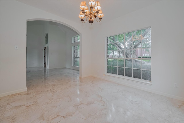 1615 Monvale Ln, Sugar Land, TX 77479 - spare room with a chandelier, marble tiled floors, and arched walkways