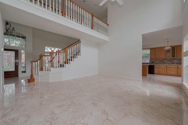 1615 Monvale Ln, Sugar Land, TX 77479 - unfurnished living room featuring a high ceiling, light marble finish floors, stairs, and a ceiling fan