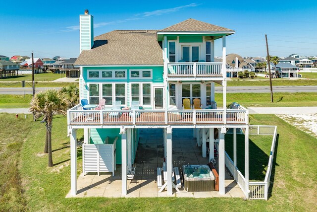 22831 Gulf Dr, Galveston, TX 77554 - rear view of property with a balcony, a patio, a yard, and roof with shingles