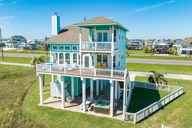 22831 Gulf Dr, Galveston, TX 77554 - back of house featuring a balcony, a shingled roof, a patio, a chimney, and a residential view