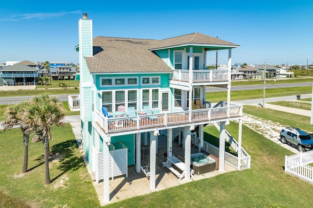 22831 Gulf Dr, Galveston, TX 77554 - back of property with a patio area, a balcony, a chimney, roof with shingles, and a deck
