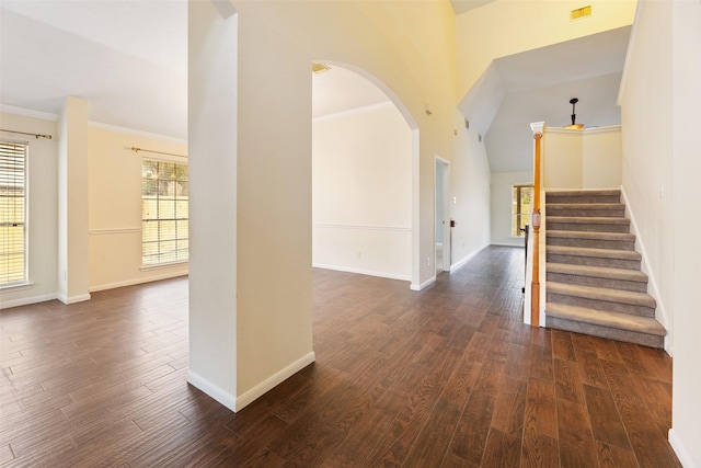 9135 Eaglecove Dr, Houston, TX 77064 - entrance foyer featuring arched walkways, dark wood-type flooring, stairway, a towering ceiling, and ornamental molding