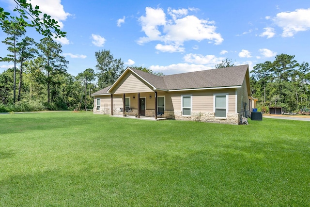 468 Brahman, Onalaska, TX 77360 - back of property featuring stone siding, a yard, a shingled roof, and covered porch