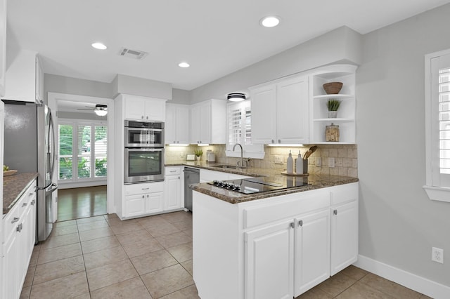 4310 Wigton Dr, Houston, TX 77096 - kitchen with stainless steel appliances, a peninsula, backsplash, white cabinets, and open shelves