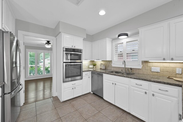 4310 Wigton Dr, Houston, TX 77096 - kitchen featuring stainless steel appliances, plenty of natural light, white cabinetry, decorative backsplash, and recessed lighting