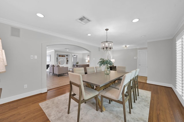 4310 Wigton Dr, Houston, TX 77096 - dining room featuring arched walkways, recessed lighting, crown molding, wood finished floors, and a chandelier