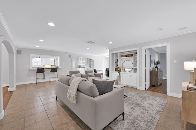 4310 Wigton Dr, Houston, TX 77096 - living area featuring arched walkways, crown molding, light tile patterned floors, recessed lighting, and built in features