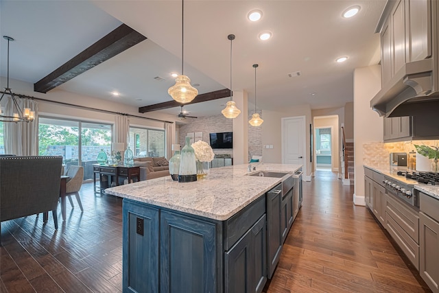 2418 Sandhill Crest Ln, Brookshire, TX 77423 - kitchen with stainless steel gas cooktop, open floor plan, a center island with sink, beam ceiling, and dark wood finished floors