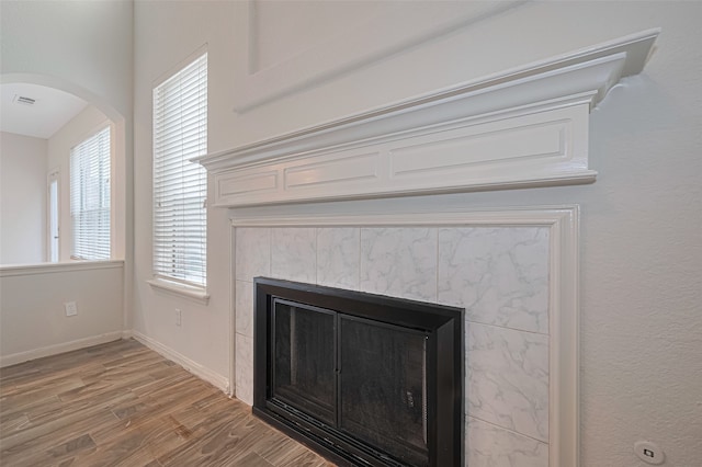 10210 Squirehill Ct, Houston, TX 77070 - detailed view of a tiled fireplace, wood finished floors, and arched walkways
