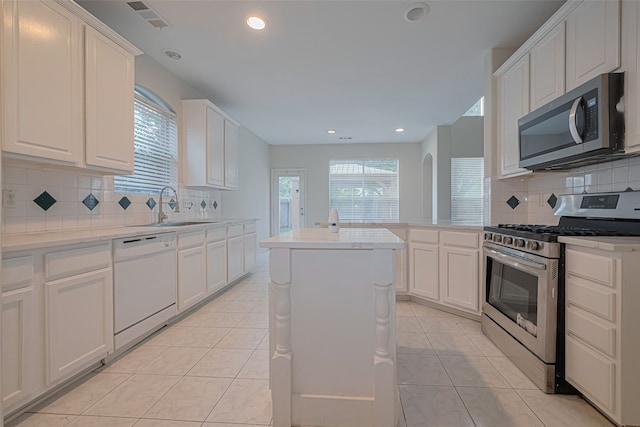 10210 Squirehill Ct, Houston, TX 77070 - kitchen with appliances with stainless steel finishes, backsplash, light tile patterned floors, white cabinets, and recessed lighting