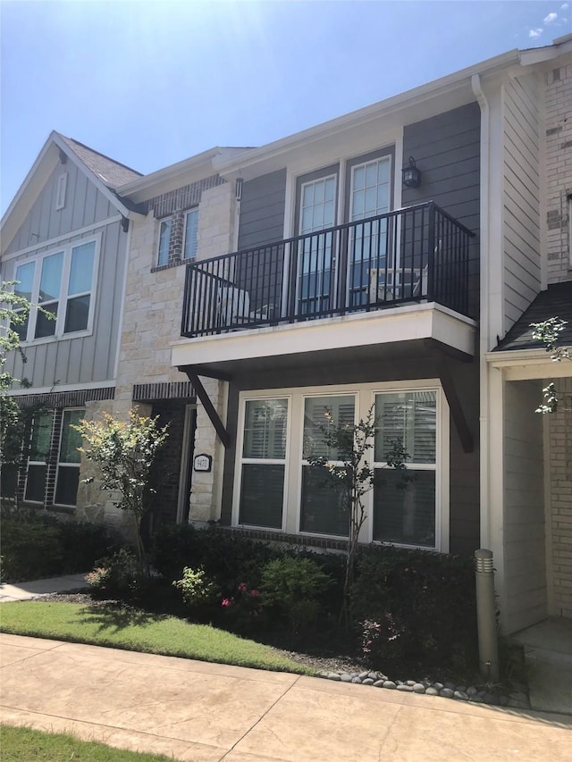 9470 Caddo Ridge Ln, Cypress, TX 77433 - view of property exterior featuring a balcony, board and batten siding, and stone siding