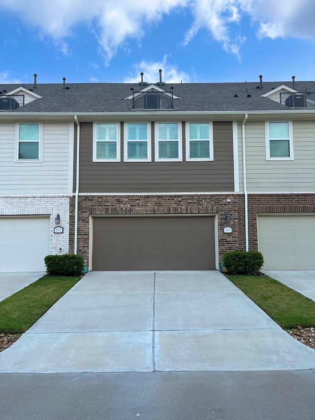 9470 Caddo Ridge Ln, Cypress, TX 77433 - townhome / multi-family property featuring an attached garage, driveway, and brick siding