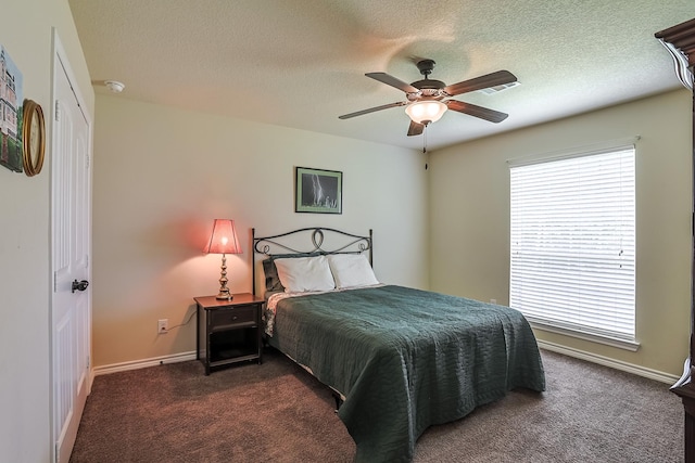 130 Canary Ln, Coldspring, TX 77331 - bedroom featuring dark colored carpet, multiple windows, a ceiling fan, and a textured ceiling