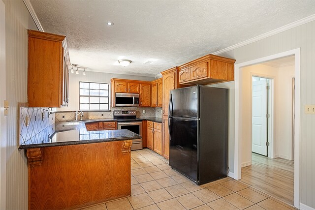 8228 Ponderosa Dr, Silsbee, TX 77656 - kitchen with appliances with stainless steel finishes, a peninsula, ornamental molding, tasteful backsplash, and light tile patterned floors
