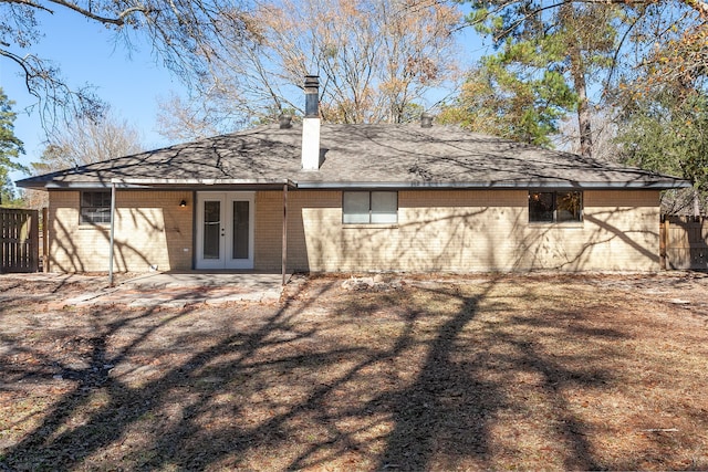 8228 Ponderosa Dr, Silsbee, TX 77656 - rear view of house with french doors, brick siding, a shingled roof, and a chimney