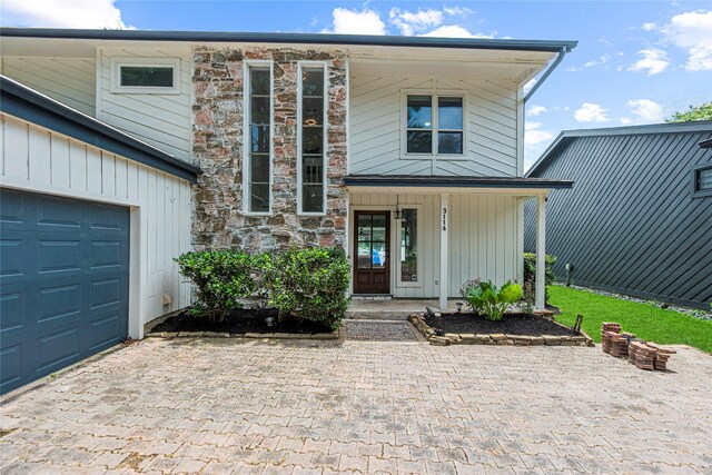 3114 Canterbury Ln, Montgomery, TX 77356 - view of front of home featuring decorative driveway, a porch, an attached garage, stone siding, and board and batten siding