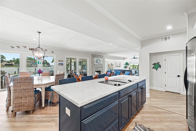 3114 Canterbury Ln, Montgomery, TX 77356 - kitchen with black electric stovetop, freestanding refrigerator, light countertops, light wood finished floors, and ornamental molding
