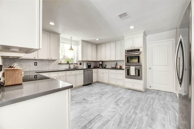 11715 Cypresswood Dr, Houston, TX 77070 - kitchen with stainless steel appliances, dark countertops, tasteful backsplash, decorative light fixtures, and a textured ceiling