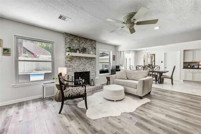 11715 Cypresswood Dr, Houston, TX 77070 - living room featuring light wood-style floors, healthy amount of natural light, ceiling fan, and a textured ceiling