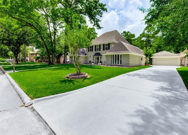 11715 Cypresswood Dr, Houston, TX 77070 - colonial-style house with an outdoor structure, a front lawn, driveway, and brick siding