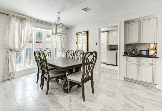 11715 Cypresswood Dr, Houston, TX 77070 - dining space featuring washer / dryer and a textured ceiling