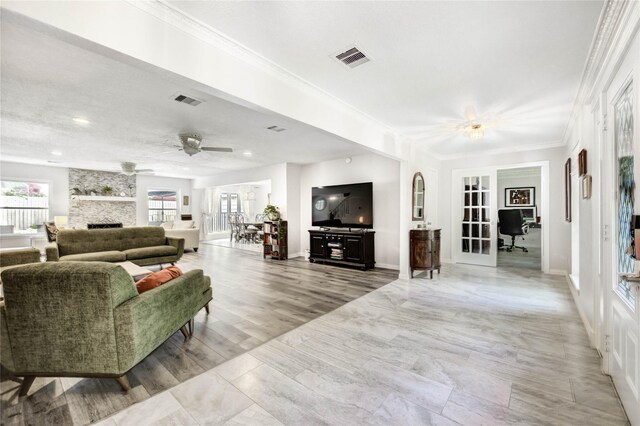 11715 Cypresswood Dr, Houston, TX 77070 - living room featuring a fireplace, ornamental molding, ceiling fan, recessed lighting, and french doors