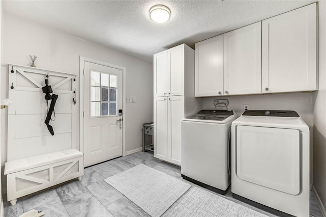 11715 Cypresswood Dr, Houston, TX 77070 - washroom featuring washer and clothes dryer, cabinet space, light marble finish flooring, and a textured ceiling