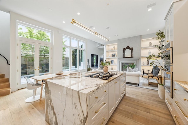 2013 Persa St, Houston, TX 77019 - kitchen with gas stovetop, french doors, open floor plan, light wood-type flooring, and built in shelves
