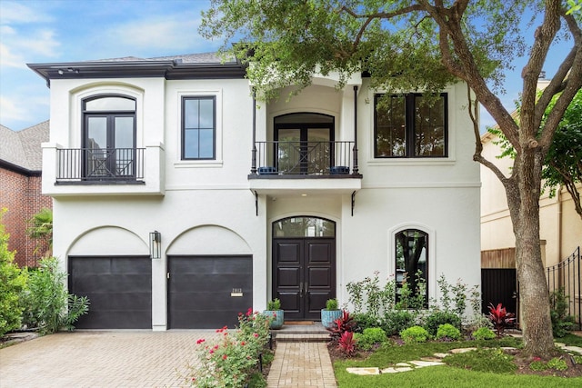 2013 Persa St, Houston, TX 77019 - view of front of house featuring a balcony, decorative driveway, an attached garage, and french doors