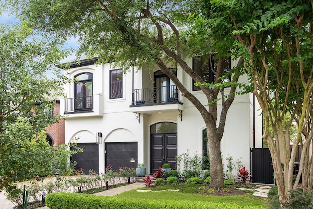 2013 Persa St, Houston, TX 77019 - view of front of property featuring a balcony, stucco siding, and an attached garage