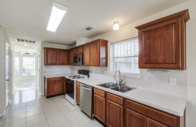 5330 Imperial Grove Dr, Houston, TX 77066 - kitchen with appliances with stainless steel finishes, light countertops, light tile patterned flooring, and brown cabinets