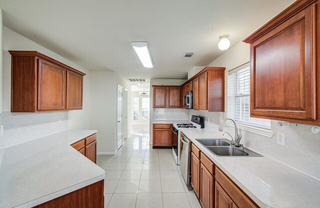 5330 Imperial Grove Dr, Houston, TX 77066 - kitchen with stainless steel appliances, light countertops, light tile patterned flooring, and brown cabinetry