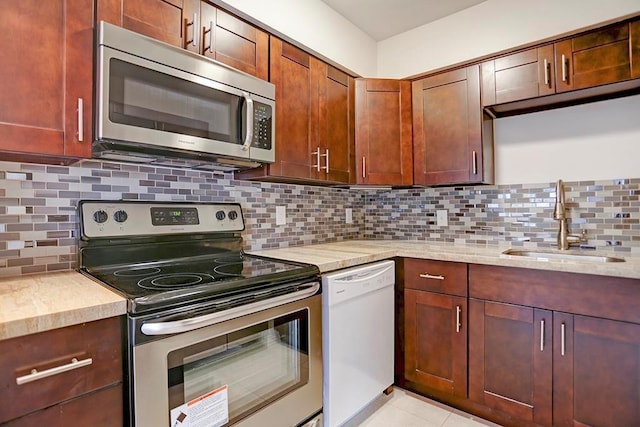 909 Silber Rd Unit 36, Houston, TX 77024 - kitchen featuring stainless steel appliances, tasteful backsplash, light tile patterned floors, and light stone countertops