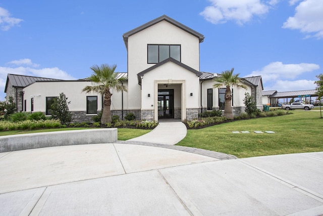 2311 Langley Dr, Rosharon, TX 77583 - view of front of property featuring a standing seam roof, french doors, stone siding, a metal roof, and a front lawn