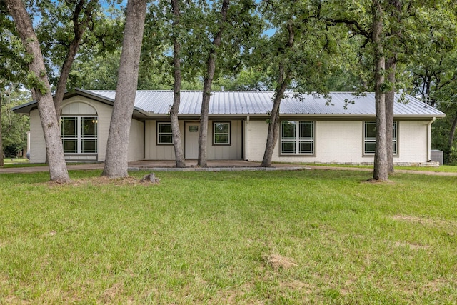 73 Fairway Dr, Normangee, TX 77871 - view of front of house featuring a front yard, a metal roof, and brick siding