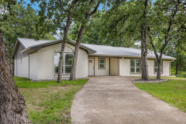 73 Fairway Dr, Normangee, TX 77871 - view of front of property with driveway, a metal roof, a front lawn, and brick siding