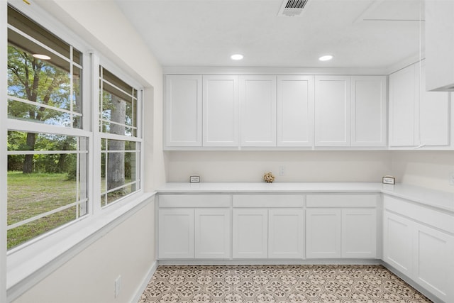 73 Fairway Dr, Normangee, TX 77871 - kitchen featuring healthy amount of natural light, light countertops, white cabinetry, recessed lighting, and light tile patterned floors