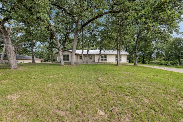 73 Fairway Dr, Normangee, TX 77871 - view of front of home with an attached garage, a front yard, stucco siding, and driveway